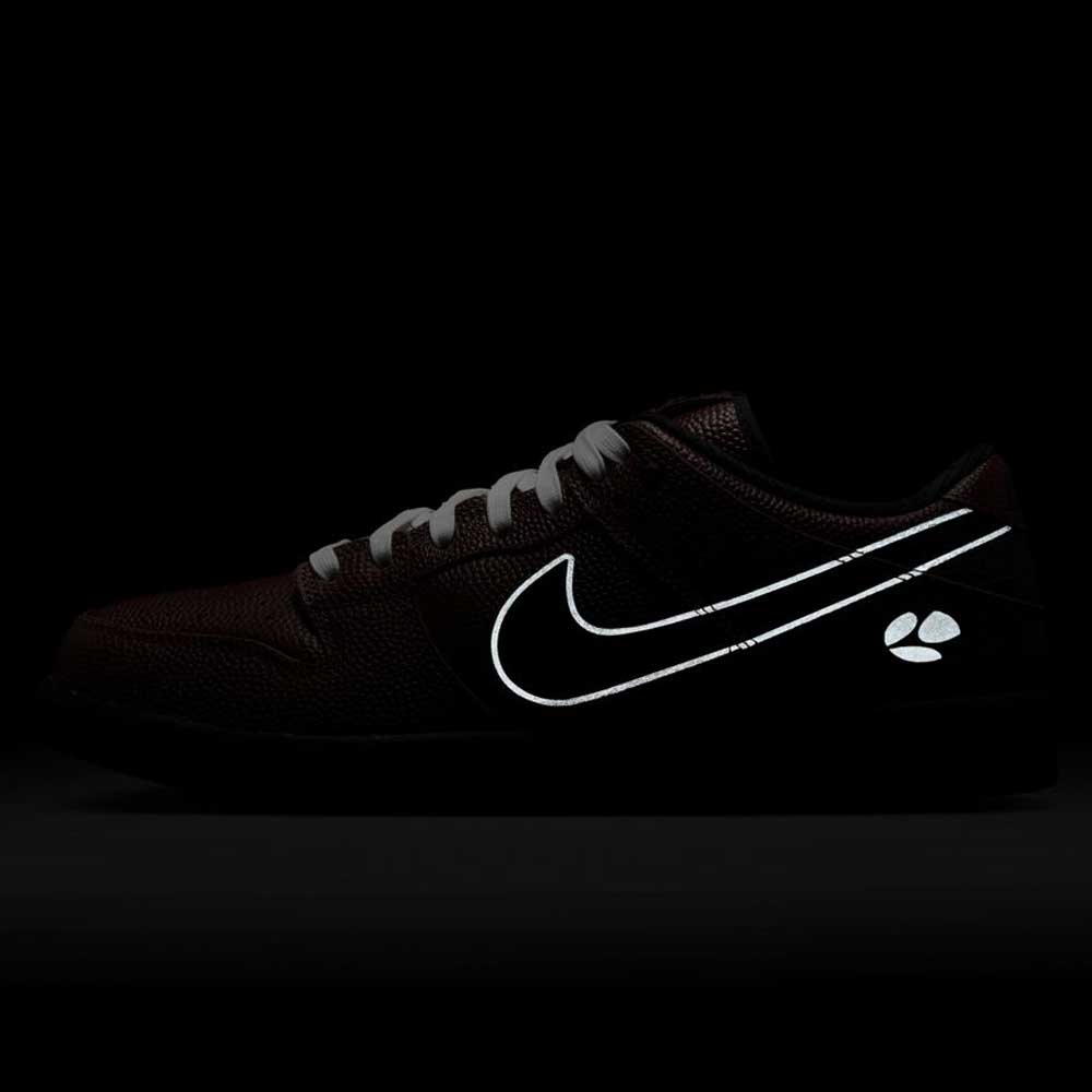 The HJ4131-200 Limosine Dark Pony Black Silver White Nike SB Dunk Low Pro skateboarding shoe features a black upper, glowing white swoosh, and reflective paw print on the heel, displayed against a dark background.
