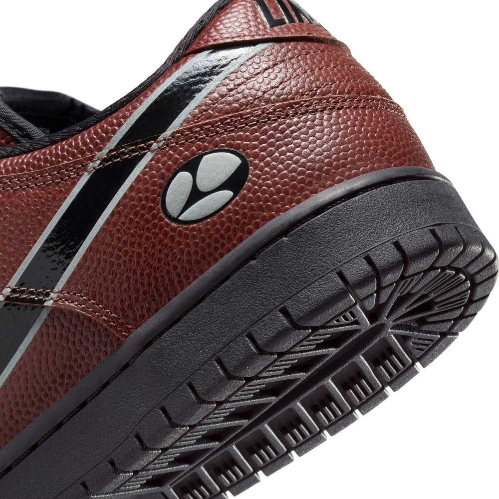 Close-up of the heel and black rubber sole of the HJ4131-200 Limosine Dark Pony Black Silver White Nike SB Dunk Low Pro Skateboarding Shoe, showing its textured brown upper, black and white stripe accents, and visible tread pattern.