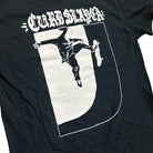 The Logo Black Tee Curbslayer features a striking graphic of a hooded skateboarder landing a trick on a curb—a must-have for true skate fans.
