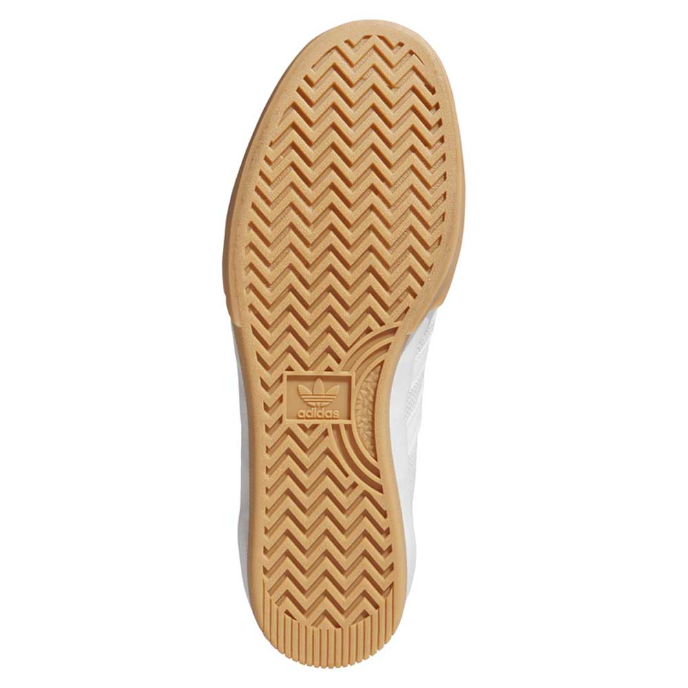 The image shows the sole of the Lucas Premiere White Coral HQ7524 Adidas Skateboarding Suede Shoe, featuring a light brown gum outsole with zigzag tread patterns and an adidas logo near the center.