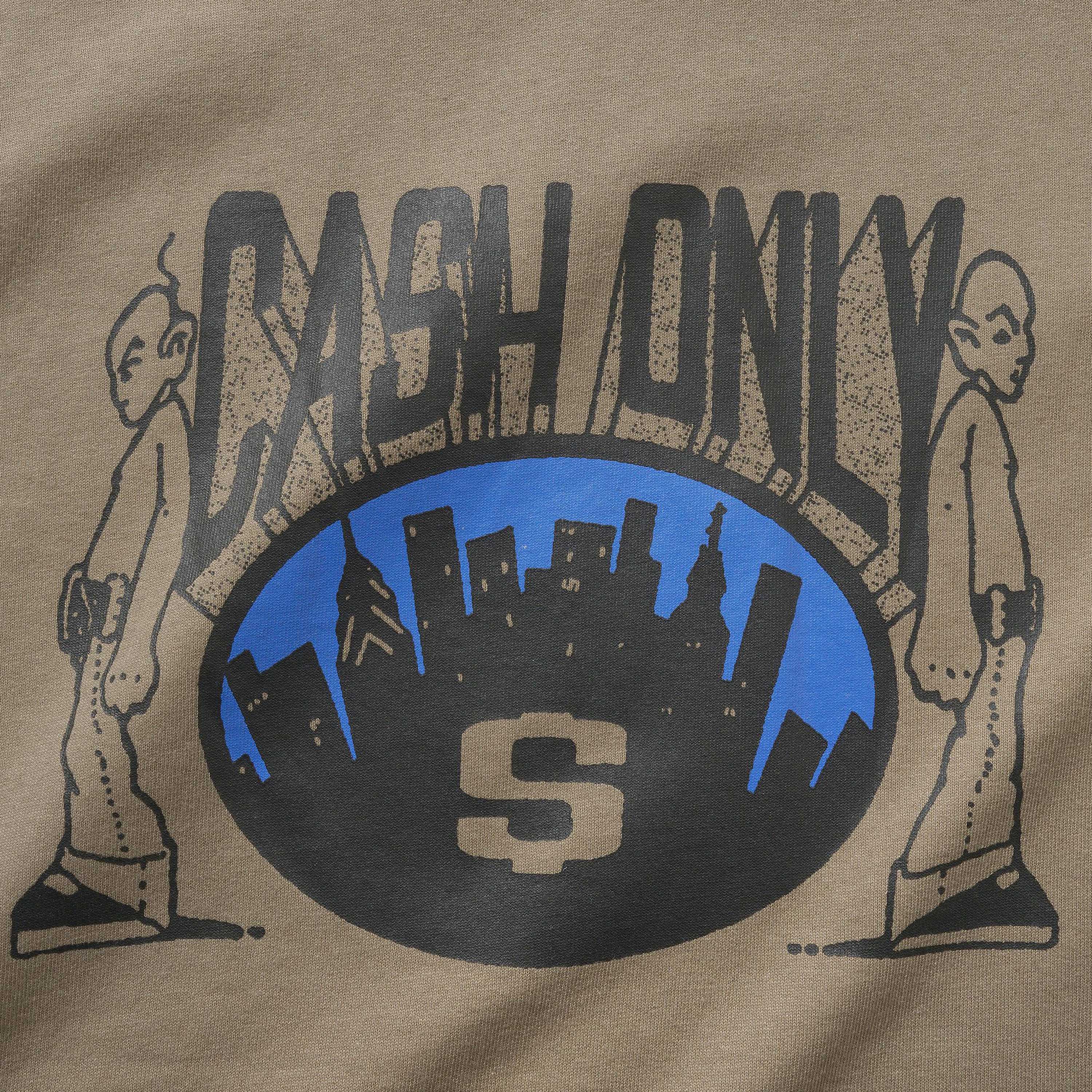 The Metro Tee Stone Cash Only features a screenprint graphic with "CASH ONLY" above a blue oval, black city skyline, large S at center, and two stylized figures, printed on a 6.5oz cotton heavyweight tee.
