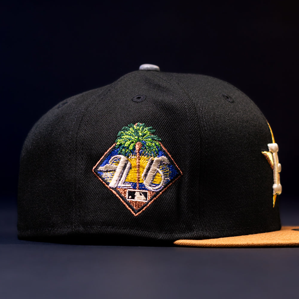 The Midsummer Night 26 Spring Bronze Houston Astros New Era Hat 5950 Fitted is a black cap with a yellow brim, featuring a colorful embroidered Astros logo with palm trees, a sunset, and "25" above the MLB logo.