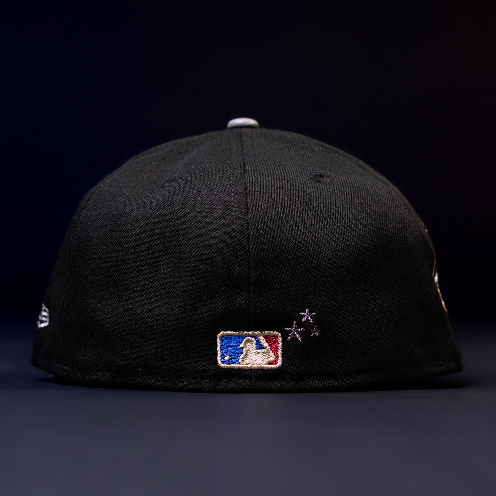 The Midsummer Night 26 Spring Bronze Houston Astros New Era 5950 Fitted cap is shown from the back, with the MLB logo embroidered at the center and three small star-shaped stitches to the right, set against a dark background.