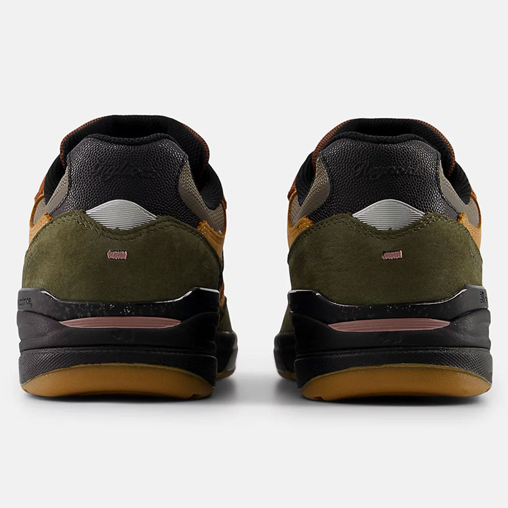 A pair of Mike Gigliotti True Brown Candy Pink 933 LOT New Balance Numeric suede skateboarding shoes viewed from the back, with olive green suede, black midsoles, tan outsoles, and brown and black accents on a light gray background.