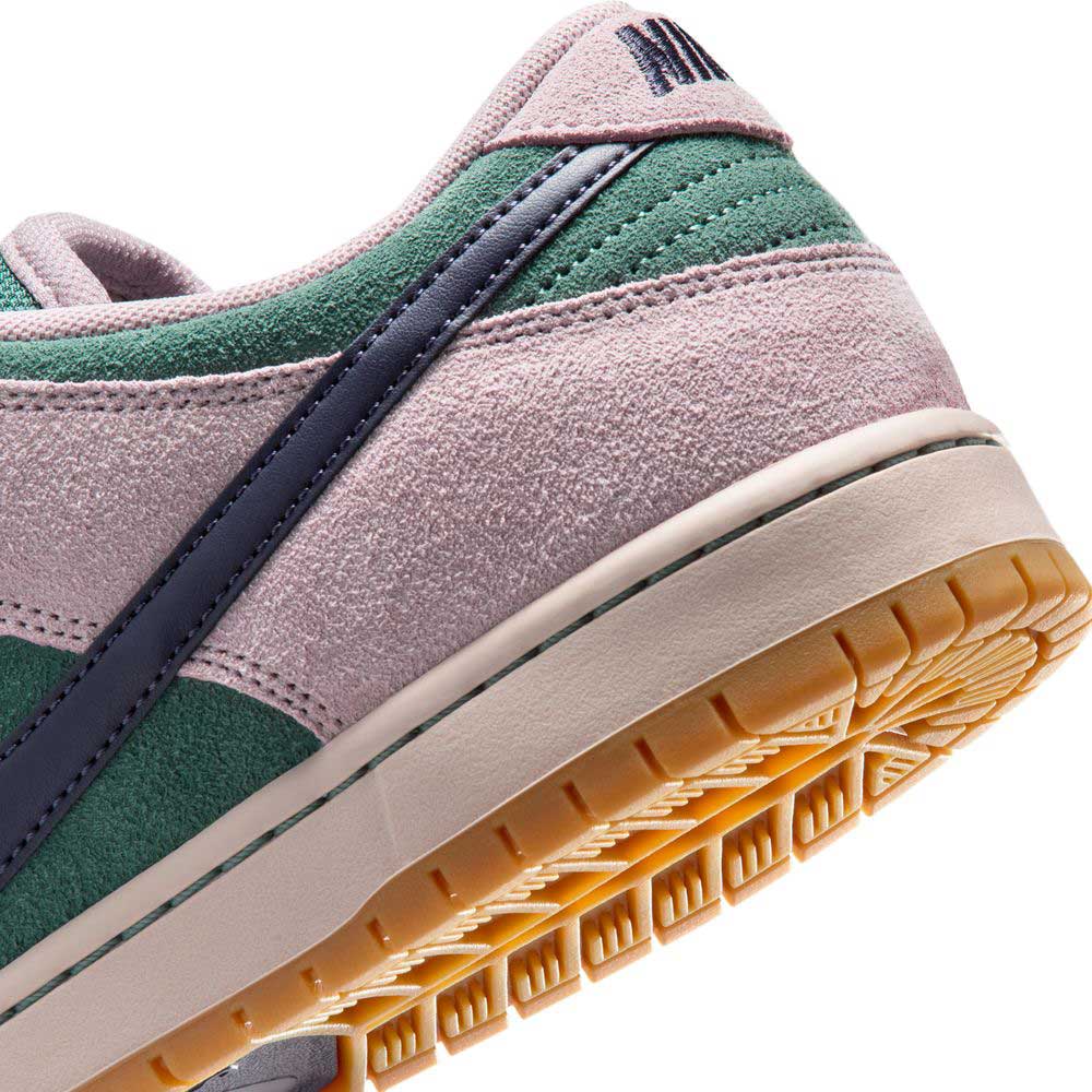 Close-up of the Minereal Slate Dark Raisin Dunk Low Pro HQ1625300 Suede Skateboarding sneaker, featuring green, pink, and purple suede panels, a dark Nike swoosh, and a tan rubber sole with classic tread pattern.