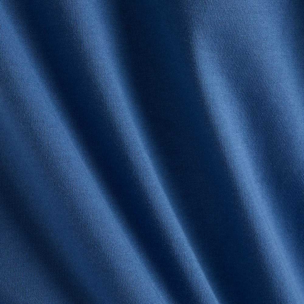 Close-up of the New Balance Numeric Small Logo Magic Blue Tee MT53706AA4, showing its soft fabric with smooth, diagonal folds and gentle shadows that highlight the relaxed fit and premium texture.