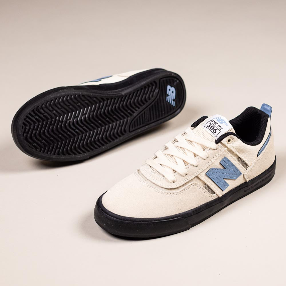 A pair of 306 SBB Jamie Foy Sea Salt Still Water New Balance Numeric suede skateboarding shoes, featuring beige uppers, black soles, blue accents, and a blue N logo—perfect for vulcanized skate shoe enthusiasts.