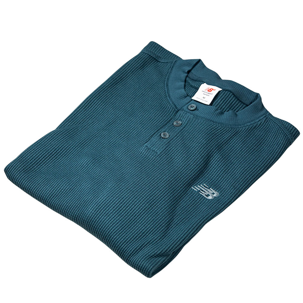 A teal New Balance Numeric Waffle Knit Tee MT51958AAV features long sleeves, a three-button henley design, embroidered chest logo, and a visible collar size tag.