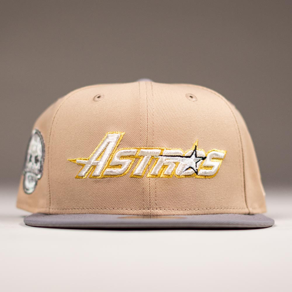 The Chalino Skull Camel Storm Houston Astros New Era 5950 Fitted Hat features "Astros" embroidered in yellow and white, a Chalino Skull patch on the left, plus a flat brim and ventilated eyelets for a signature look.