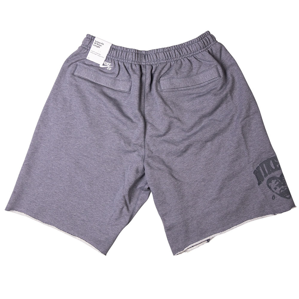 The IF1602065 Gray Sweat Short Skate Shorts by Nike SB feature a light gray color, elastic waistband, two back pockets, a small Nike tag, and a subtle graphic near the left hem. They are loose fit and displayed flat on a white background.