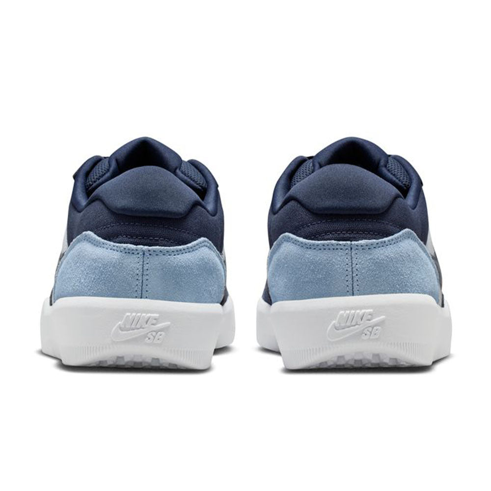 A pair of Nike SB Force 58 Light Armory Blue Thunder Photon Dust DV5477-404 suede skateboarding shoes seen from the back, featuring dark blue uppers, light blue suede heel panels, white soles, and embossed Nike SB logos on the heels.