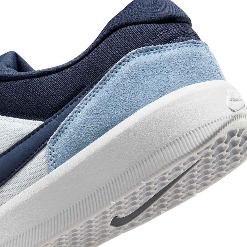 Close-up of the heel of the Force 58 Nike SB Light Armory Blue Thunder Photon Dust DV5477-404, featuring a white sole, light blue suede accents, navy details, and mesh upper—blending heritage basketball style with modern cupsole grip for skateboarding.