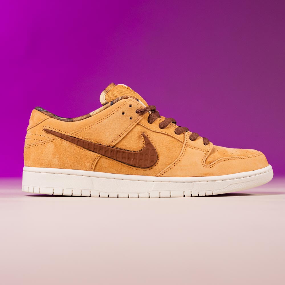 The READ BELOW the BUTTON RAFFLE Nike SB Brew and Biscuits Dunk Low features tan and brown suede, brown laces, and a white sole against a pink-purple gradient—ideal for your next Southside Skatepark raffle entry.