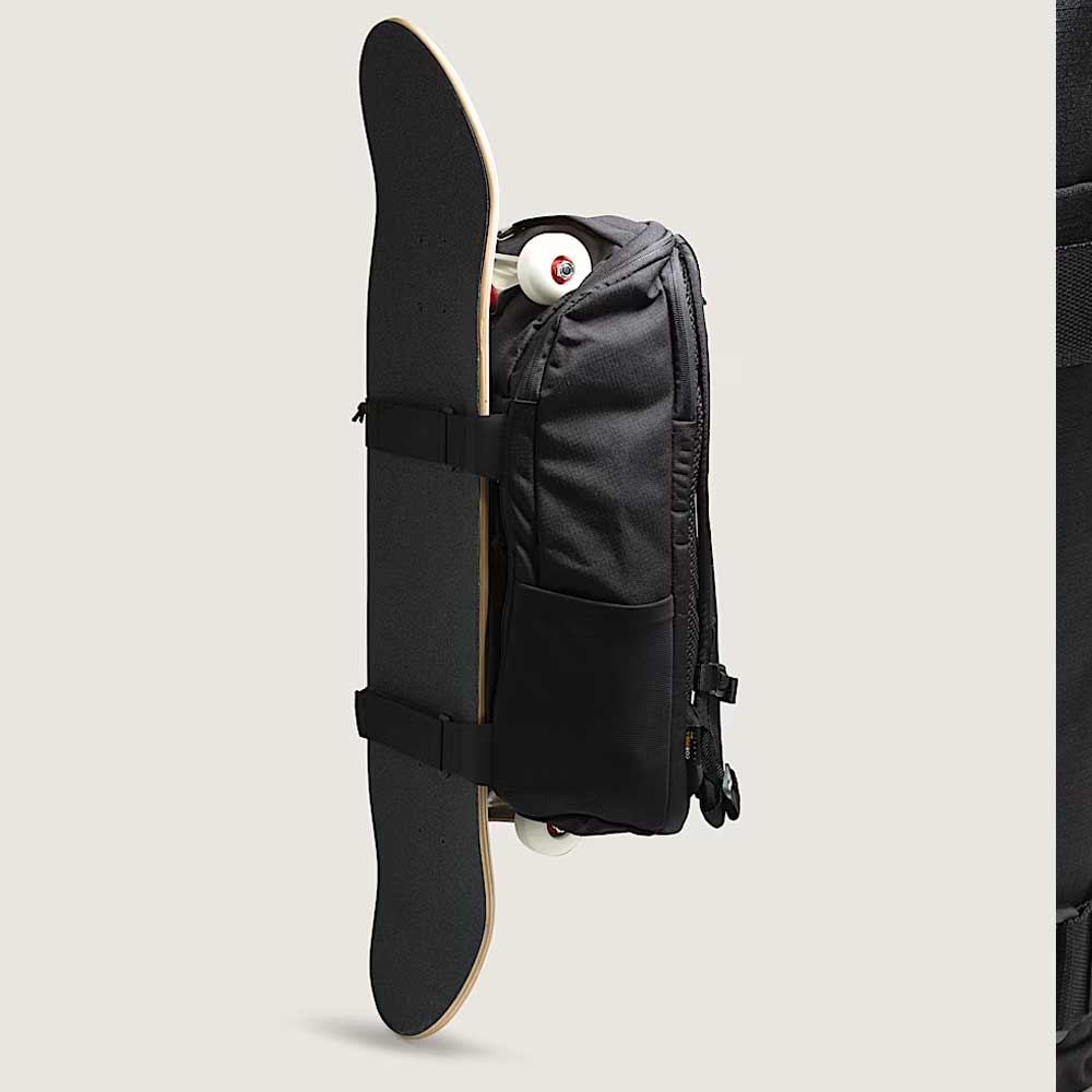 The Obstacle Skatepack Backpack VN0A3I696ZC1 Black Ripstop by Vans Skateboarding, shown in profile with side straps securing a vertically attached skateboard and wheels visible above, is ideal as a skatepack or laptop backpack.