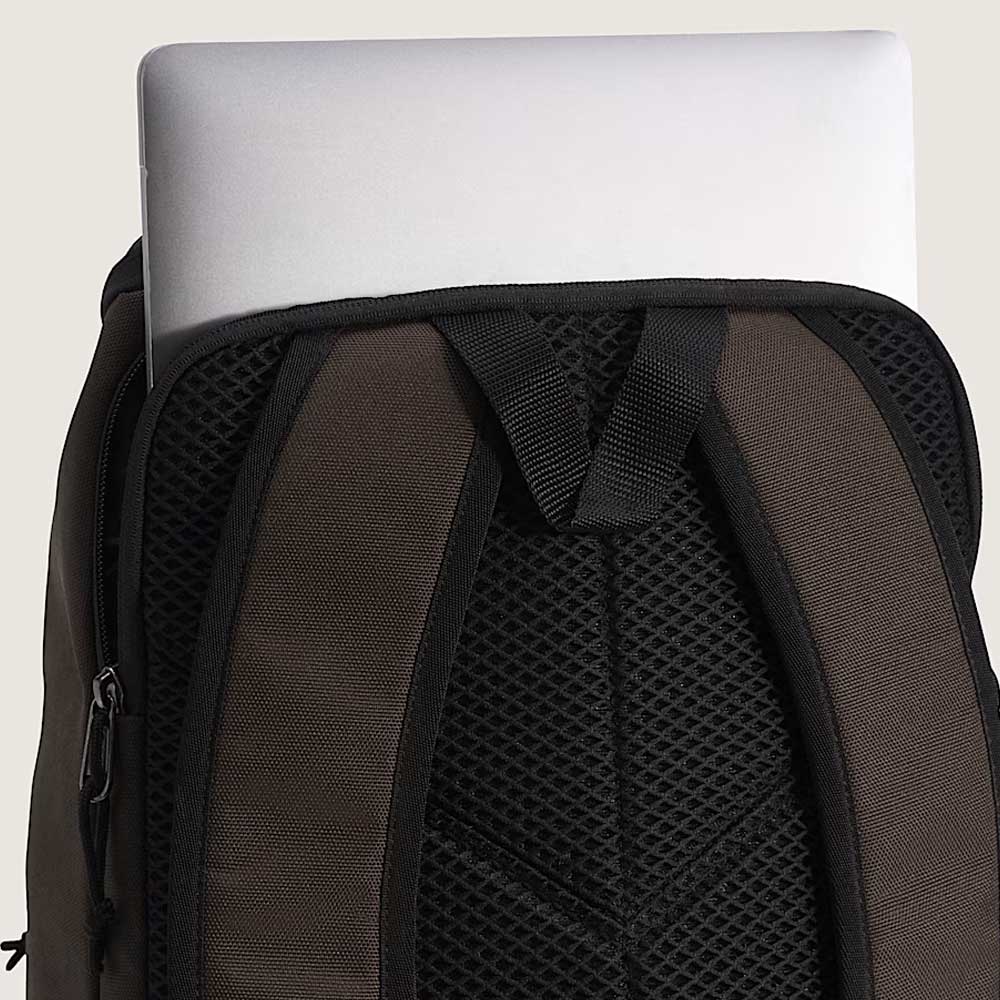 A silver laptop partially tucked into the laptop compartment of an Obstacle Skatepack Backpack VN0A3I69OVB1 Brown Ripstop by Vans Skateboarding with padded mesh straps.