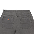 Back view of the P415259 Loose Double Knee Woven Denim Jean in Grey Wash Tinted by Dickies Skateboarding, featuring two large rear patch pockets with a small Dickies logo on the left and visible belt loops.