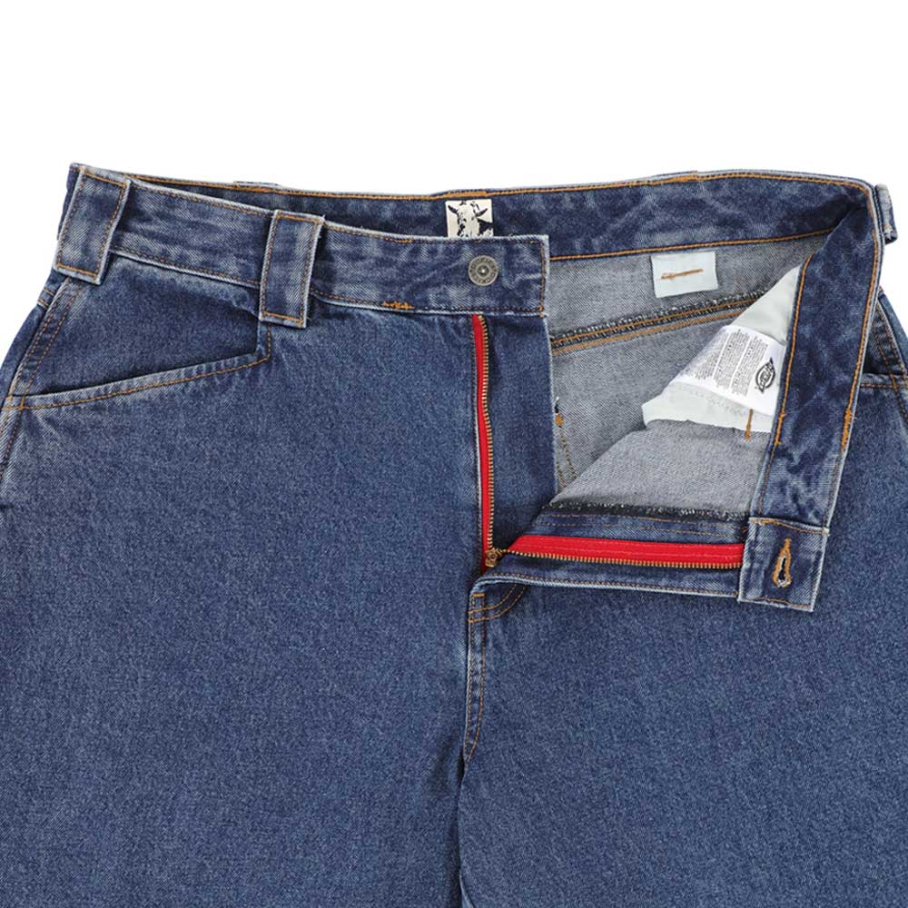 The P415316 Mike Anderson Stonewashed Denim Jean by Dickies Skateboarding in blue features a loose fit with the waistband unbuttoned and zipper partially open, showing a red zipper and visible inner fabric tags.