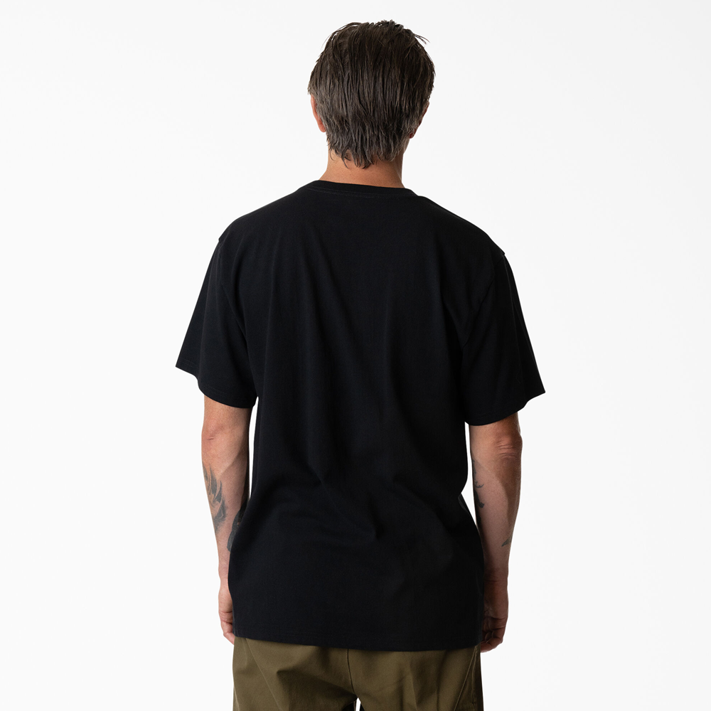 A person with short brown hair stands facing away, arms relaxed, wearing the Dickies Skateboarding P415867 Mike Anderson Goat Black Tee and olive green cooling-finish pants against a white background.
