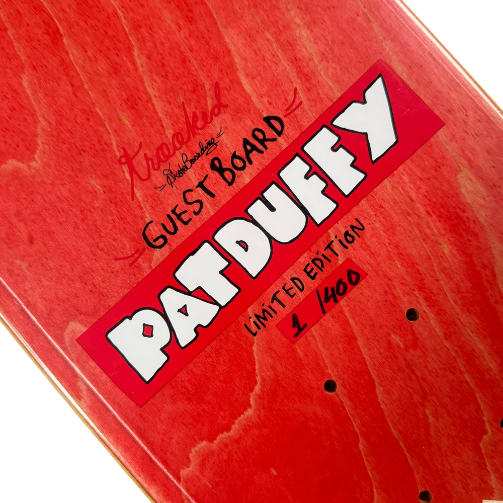 A close-up of the Pat Duffy Number 1 of 400 Guest Krooked Deck 7.6x31.25 Collectible shows handwritten “Guest Board” and “Pat Duffy” text, with "Limited Edition 1/400" and visible wood grain beneath the design.