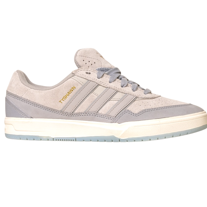 The JI0848 Granite White Tyshawn 2 II Adidas Skateboarding Shoes feature light gray suede and leather, three stripes, gold TYSHAWN branding, a white sole with a translucent light blue bottom, and are inspired by the Tyshawn II skateboard design.