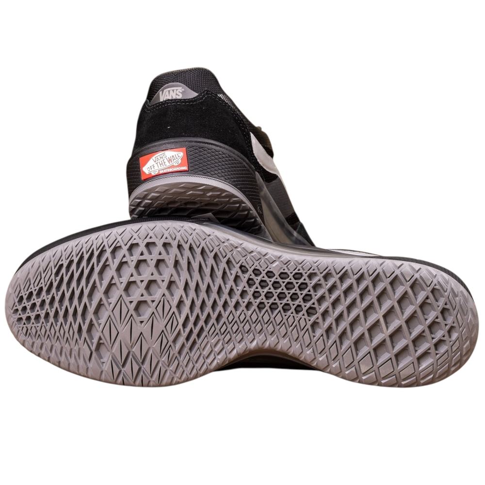 A pair of VN000DA1B5T1 Black Metallic Skate Ave 2.0 Vans Suede Skateboarding Shoes—one upright, the other tilted showing its gray textured sole and red Off the Wall logo—designed for high-performance skateboarding.