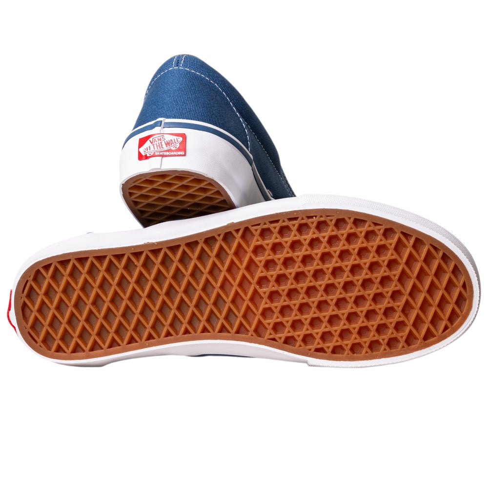 A pair of VN0A5FCANVY1 Navy Skate Slip On Vans Canvas Shoes—one upright, the other showing its brown waffle-patterned sole. The white Vans Off The Wall heel logo and POPCUSH cushioning combine classic style with added comfort.