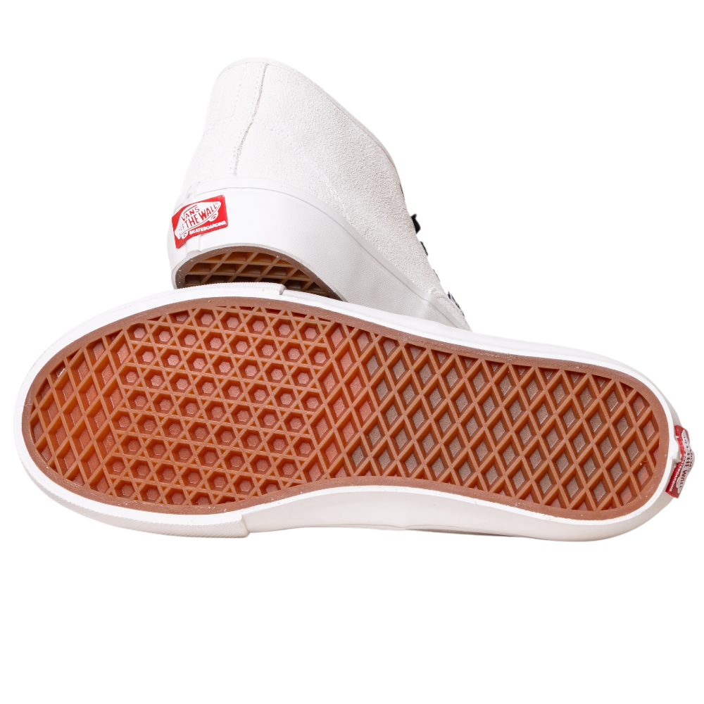 A pair of VN000EJSJVY Blanc de Blanc Authentic Mid Vans Skate Suede Shoes with white canvas uppers and brown waffle-patterned rubber soles; one lies on its side to show the outsole, while the other stands upright behind. Red and white branding appears on each heel.