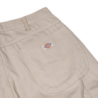 Close-up of the back pocket on the 1939 Rinsed Desert Sand Duck Relaxed Utility Jean Denim Pant by Dickies Skateboarding, featuring a sturdy, textured fabric and a small Dickies logo patch—ideal for men's workwear and relaxed fit carpenter styles.