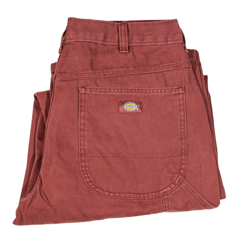 A pair of A87PE Burgundy Andorra Double Knee Canvas Carpenter Pants from Dickies Skateboarding, folded neatly, featuring a large front pocket with a visible Dickies logo patch.