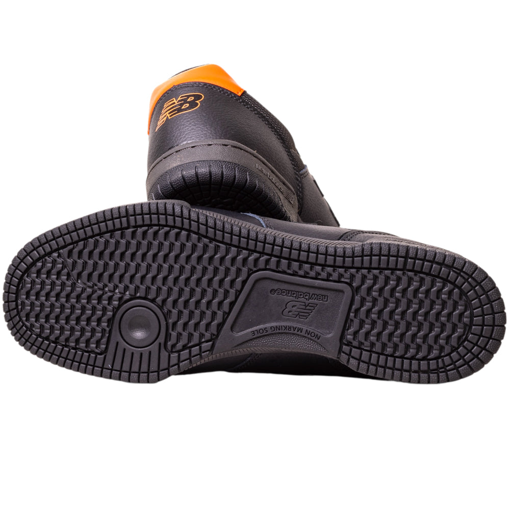 The 600TOO Black Orange Tom Knox New Balance Numeric Leather Skateboarding Shoe features an orange heel detail, patterned sole, FuelCell foam cushioning, and a bold New Balance logo—all visible from the bottom view.