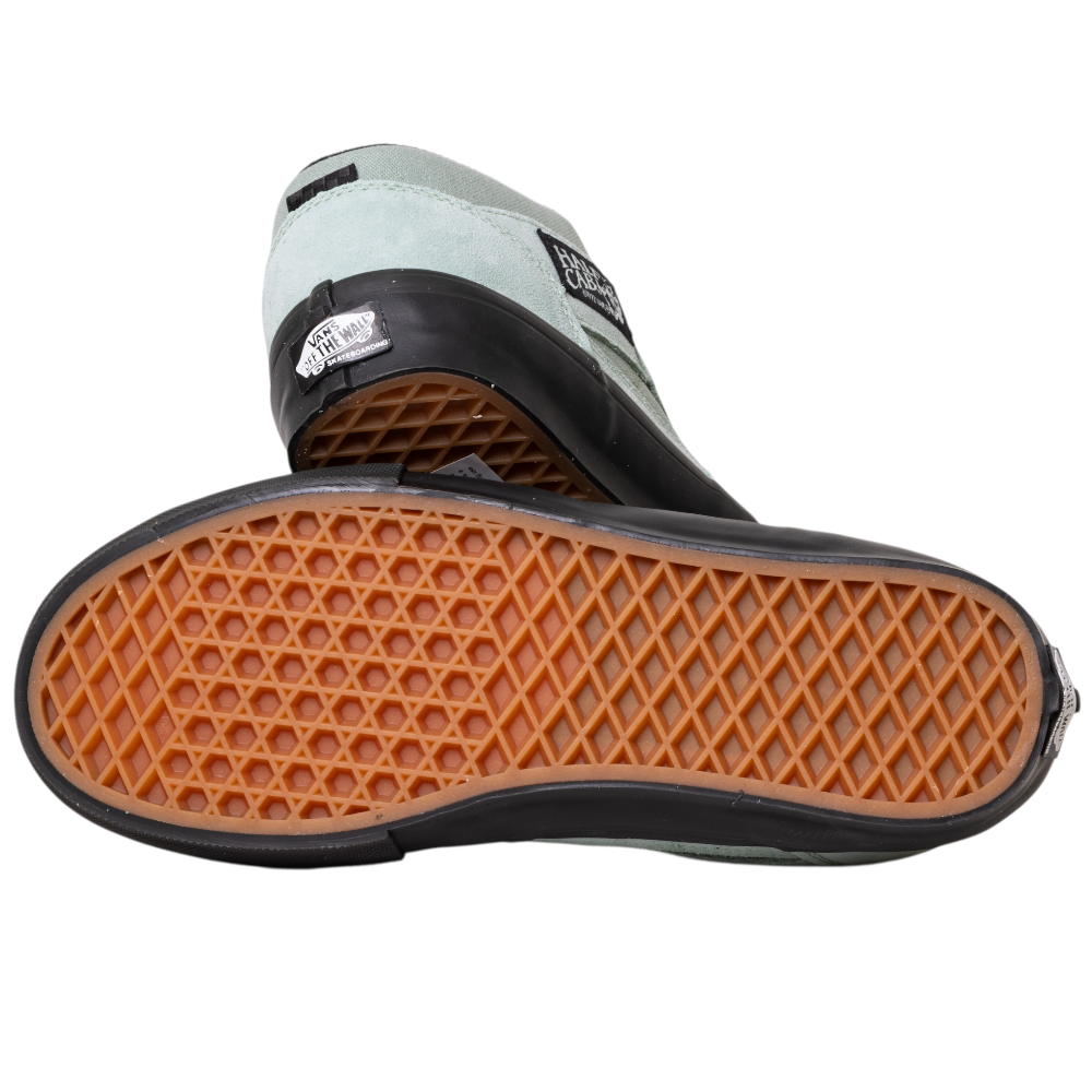 A pair of VN0A5FCDEMW1 Gray Olive Suede Skate Half Cab Vans Shoes, one showing the black and white profile with a Vans label, the other revealing the brown waffle-patterned sole, combine classic skate style with PopCush comfort.
