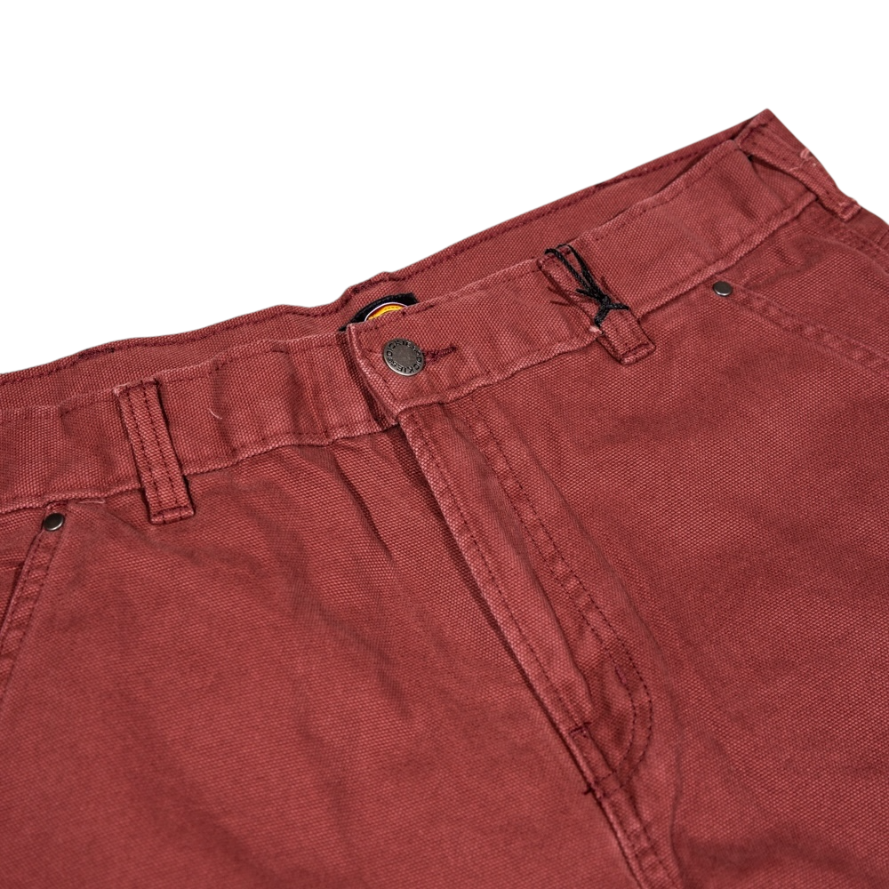 A close-up of the waistband and upper section of the A87PE Burgundy Andorra Double Knee Canvas Carpenter Pant Dickies Skateboarding, featuring belt loops, a metal button, zipper fly, and visible stitching details.