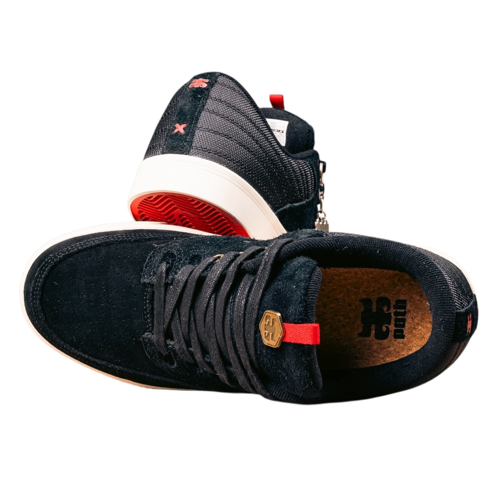 The Poet Black Suede Ballistic Nylon I Path Skateboarding Shoes feature black low-top design, red accents, white soles, and brown insoles. One shoe is upright, showing the laces; the other is tilted, displaying the side and sole.