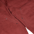 Close-up of two maroon pockets with visible stitching and metal rivets, showcasing the sturdy construction of the A87PE Burgundy Andorra Double Knee Canvas Carpenter Pant from Dickies Skateboarding.