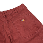 Close-up of the back of A87PE Burgundy Andorra Double Knee Canvas Carpenter Pant by Dickies Skateboarding, showing a large pocket, a small Dickies logo tag, sturdy fabric, and visible stitching on these baggy fit work pants.