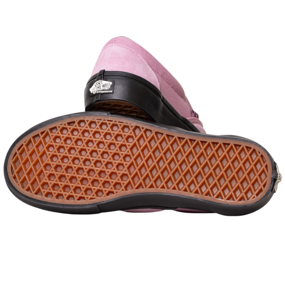 A pair of VN0A5FCAPIB1 Pink Black Skate Slip On Vans Suede Shoes, one upright and one sole up, show off the signature waffle-patterned outsole for superior board control and durability.
