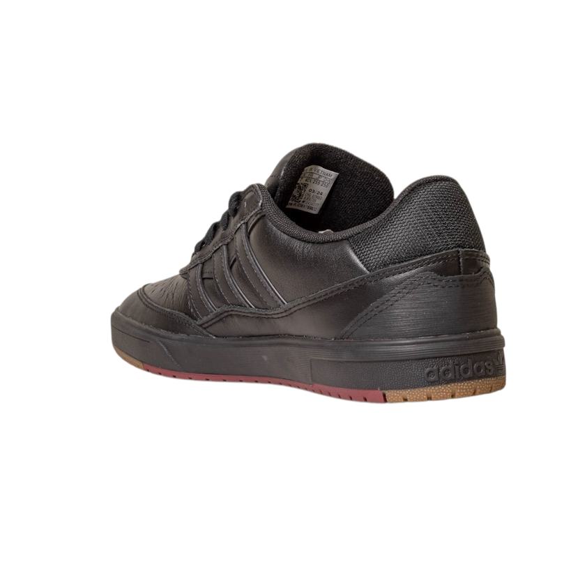 The Tyshawn 2 II Adidas Skateboarding Shoe in Core Black/Core Green leather is shown from the back left, highlighting a textured heel, Adidas heel branding, and a dark rubber sole with brown accents on a white background.