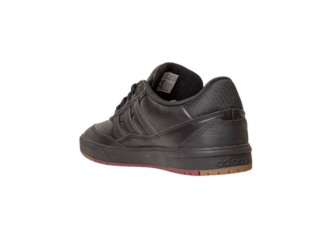 The Tyshawn 2 II Adidas Skateboarding Shoe in Core Black/Core Green leather is shown from the back left, highlighting a textured heel, Adidas heel branding, and a dark rubber sole with brown accents on a white background.