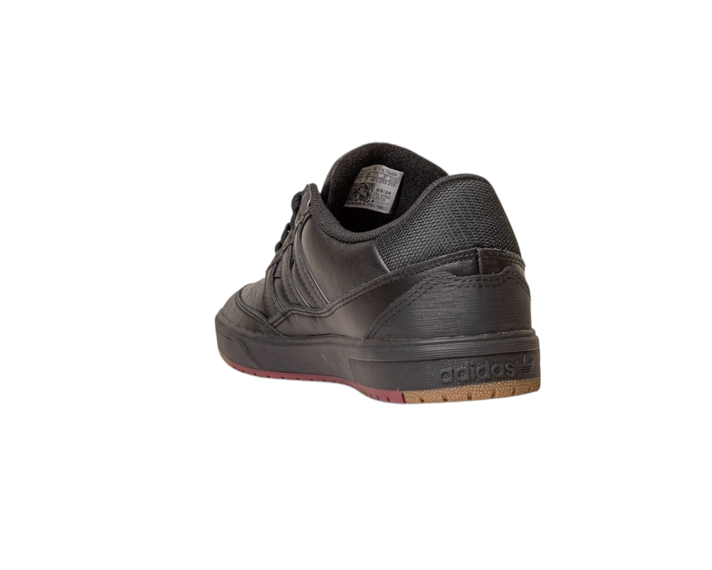 The Tyshawn 2 II Adidas Skateboarding Shoes, shown in Core Black/Core Green leather, are viewed from the back and side, highlighting the heel, brown-edged sole, stitched leather, and embossed Adidas logo on the heel.