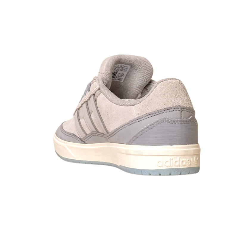 The JI0848 Granite White Tyshawn 2 Skateboarding Shoe by Adidas features leather and suede accents, highlighted from the back left to display the Adidas logo on the heel and its white and light gray rubber sole.
