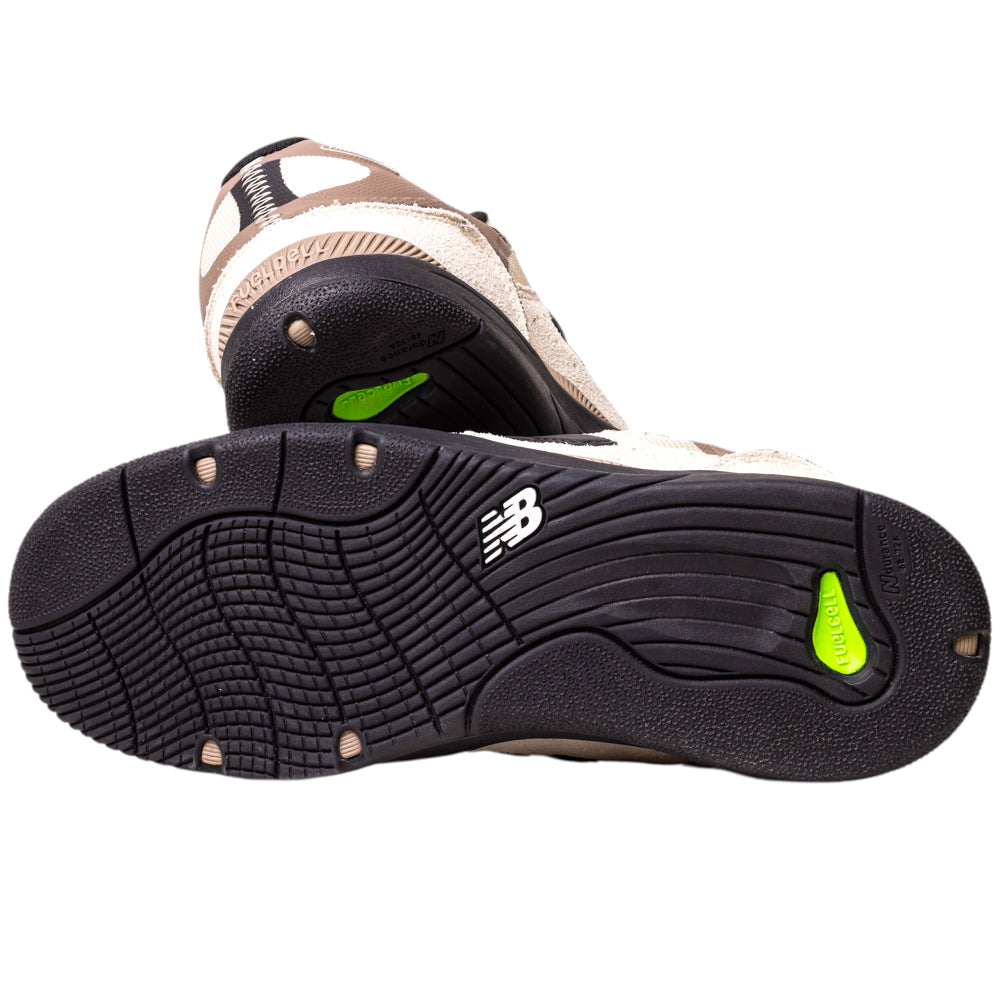 The image displays the soles of 1010NS Linen Black Tiago Lemos New Balance Numeric Suede Skateboarding Shoes, with black textured rubber, green accents, and branding. The sole-up view emphasizes their grip pattern and design details.