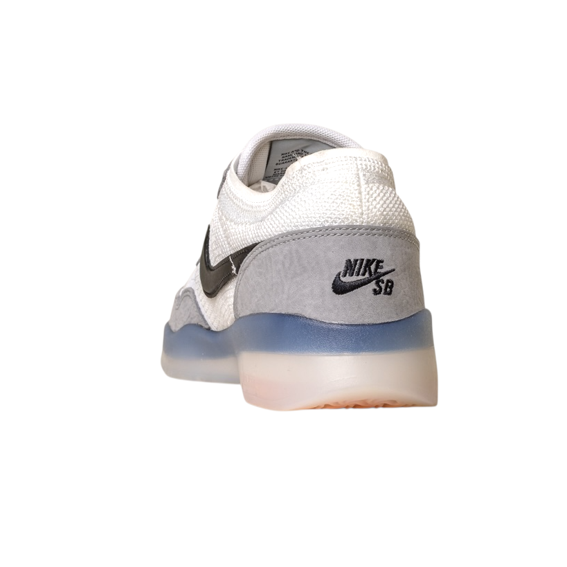 A back-right view of the FV8493004 Grey White PS8 Nike SB Leather Knit Shoes with black swoosh and logo, Flyknit leather details, translucent blue and white Air Zoom sole, shown on a white background.