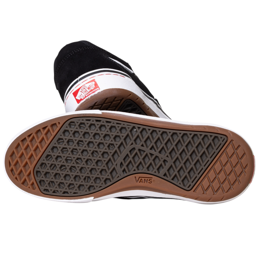 A close-up of the VN000DA4MCG1 Skate Kyle Walker Wafflecup Black White Vans shows the waffle tread sole, Vans logo, PopCush cushioning, parts of the black and white suede upper, and red heel logo—ideal for Kyle Walker fans.