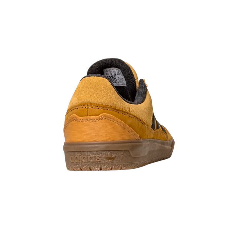 The JI0851 Mesa Black Gum Tyshawn 2 II Adidas leather suede skateboarding shoe, shown from the back-left, features a yellow suede upper, black lining, and an embossed Adidas logo on its translucent brown rubber cupsole.