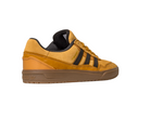 The JI0851 Mesa Black Gum Tyshawn 2 Adidas Leather Suede Skateboarding Shoe features mustard yellow suede and leather, black stripes and lining, a brown rubber sole, cupsole construction, and is displayed on a white background.