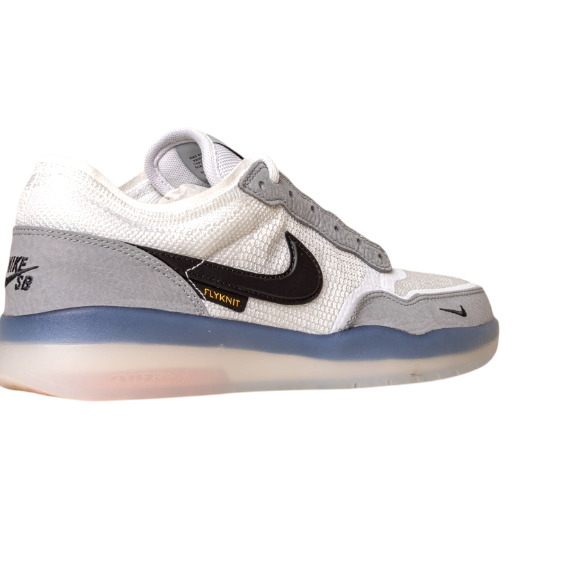 The FV8493-004 Grey White PS8 Nike SB Leather Knit Shoes are low-tops featuring a white and gray upper, black Swoosh, FLYKNIT label, HART outsole, translucent blue sole, and NIKE SB branding on the heel.