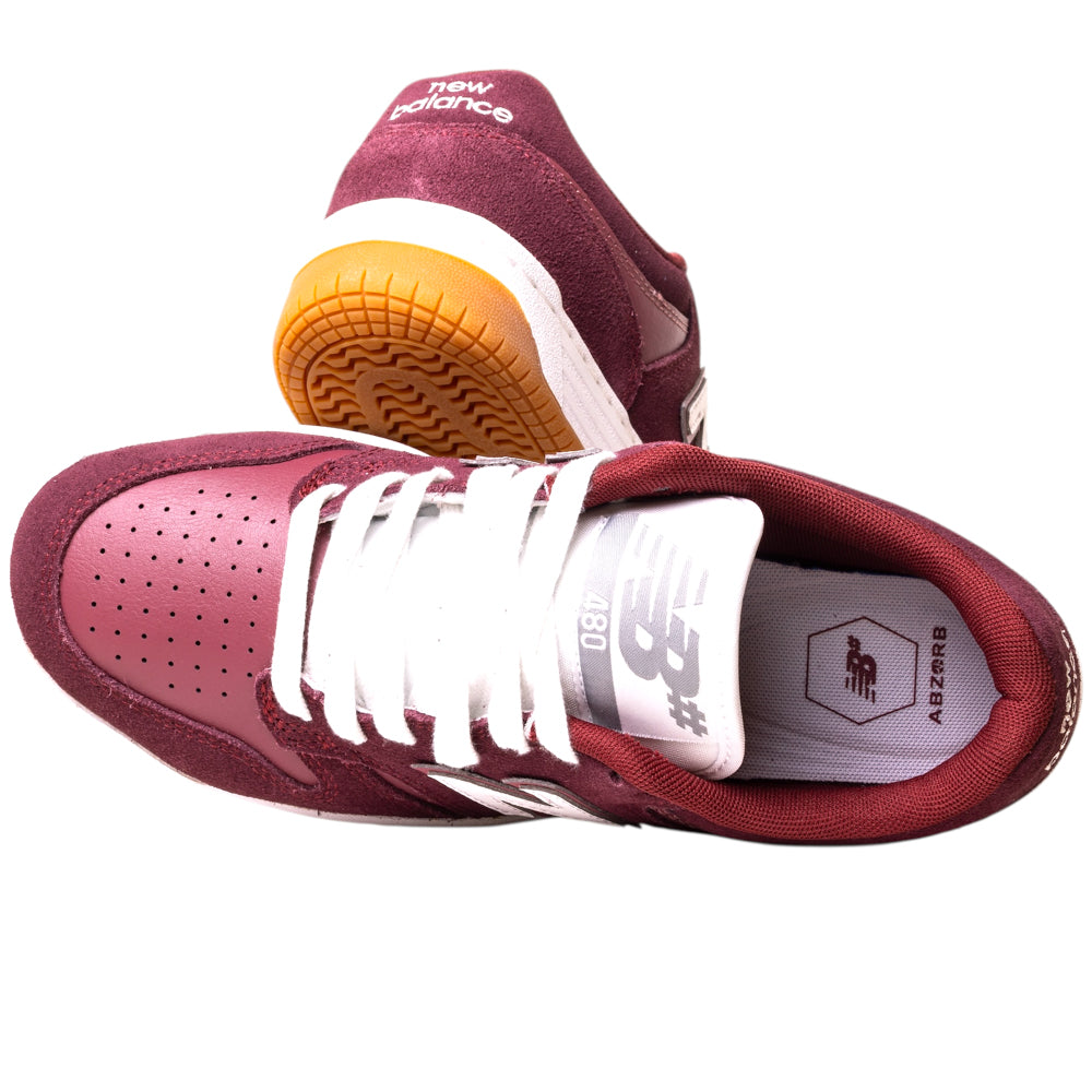 A pair of 480PRO Monarch Burgundy New Balance Numeric suede skateboarding shoes with white laces, white soles, and a gum tread. One shoe stands upright, the other lies on its side, showing the logo and 1887 on the tongue.