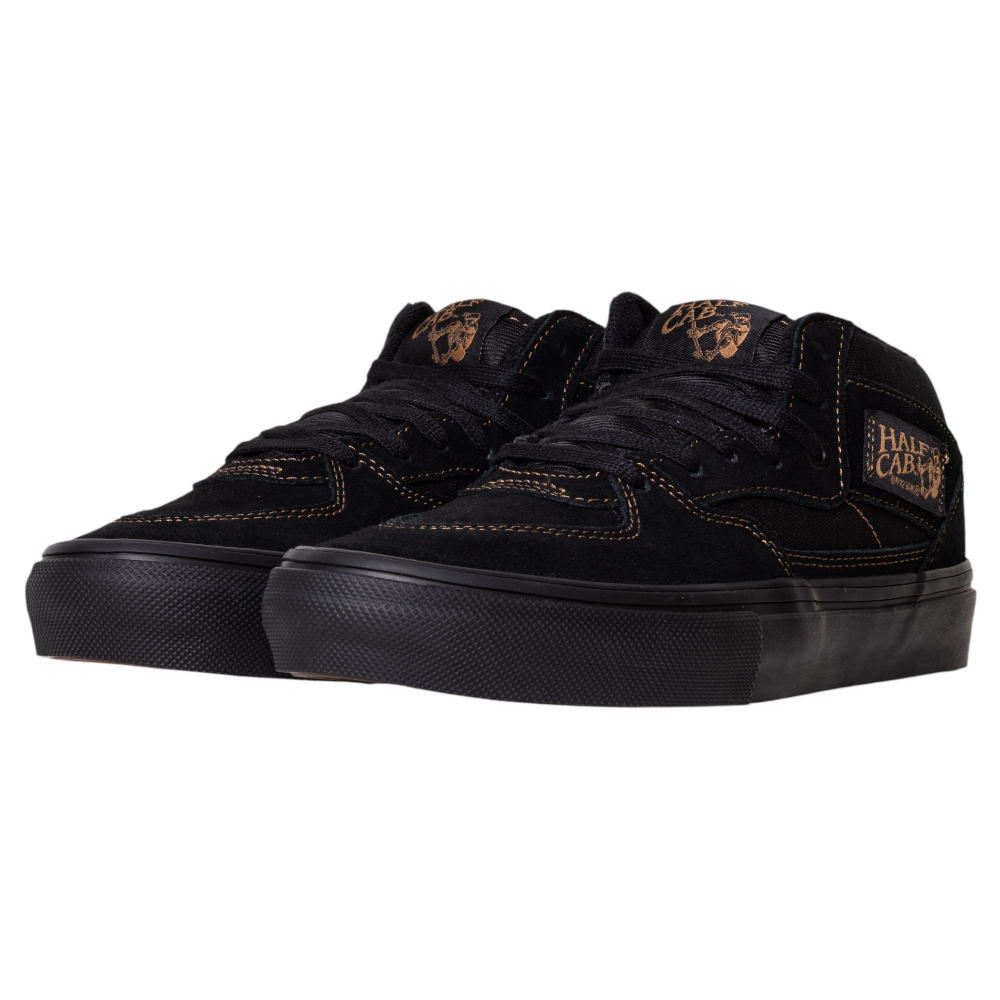 The VN000E8QGSL Black Black Brown Suede Skate Half Cab Vans Shoes feature black suede uppers, brown stitching, black laces, PopCush footbeds, a black rubber sole, and a HALF CAB patch in brown. The shoes are angled to the left.