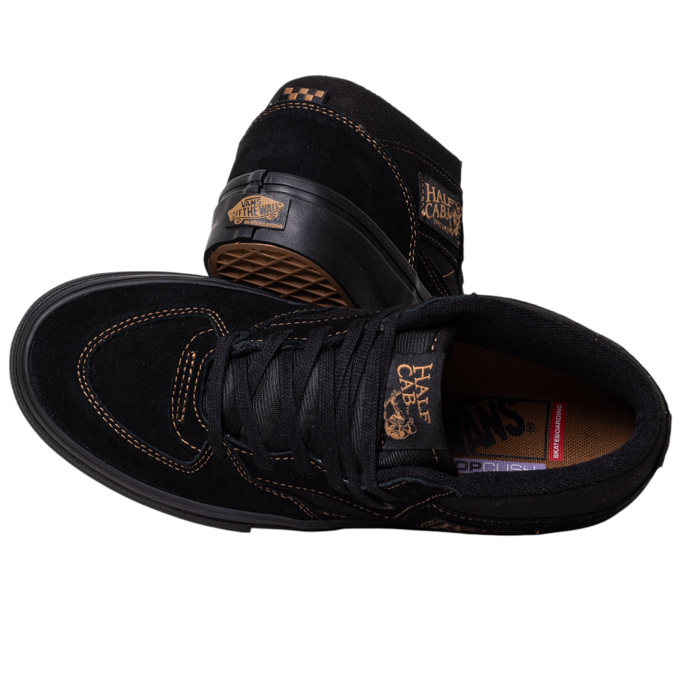 A pair of VN000E8QGSL Black Black Brown Suede Skate Half Cab Vans shoes feature brown stitching, waffle-patterned sole, visible heel logo, and PopCush footbeds. One shoe is upright; the other is on its side.