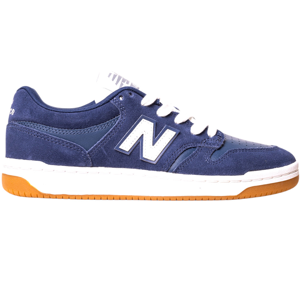 The 480BEE Navy White New Balance Numeric Suede Skateboarding Shoe features a navy blue suede upper, white laces, a white “N” logo on the side, white midsole, and brown rubber outsole, shown side profile against a white background.